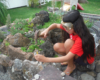 girl works in garden railway with stones