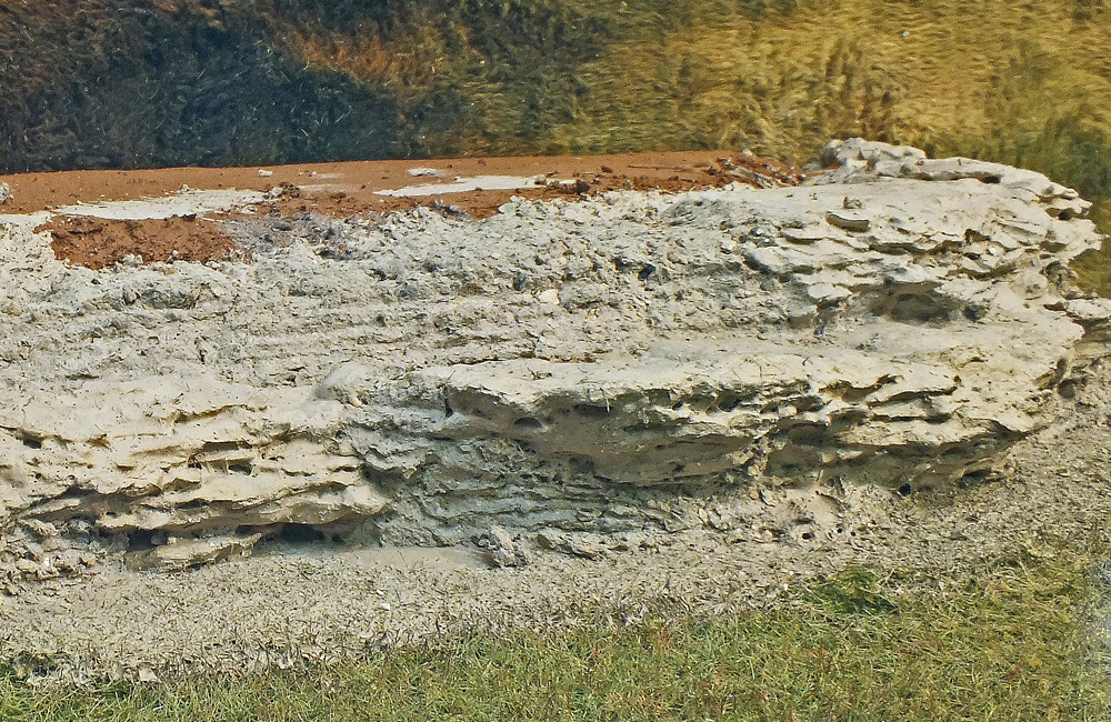 Gray-painted tree bark representing rocks are installed on a model railroad