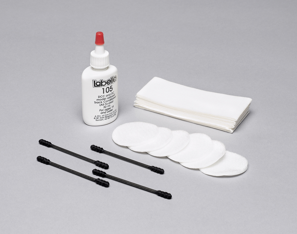 Photo of track cleaning fluid and accessories on white background.