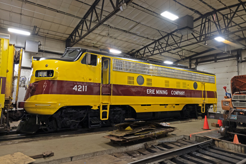 yellow and maroon diesel locomotive in shop