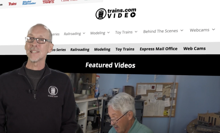 Man in front of a video screen.
