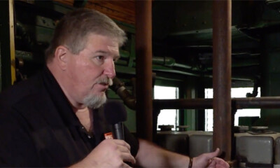 Man in a work area speaking into a microphone.