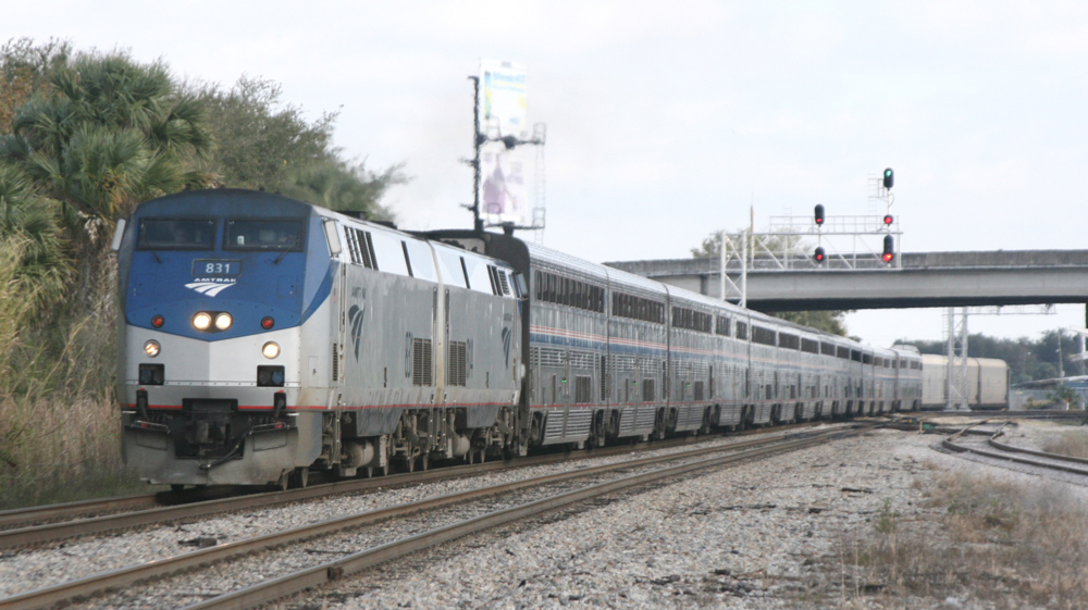 Long passenger train with auto racks at back on double track main line