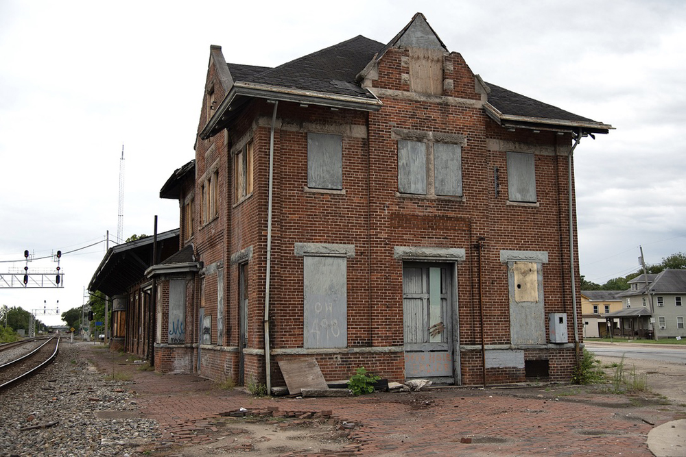 Brick two-story station building next to railroad tracks