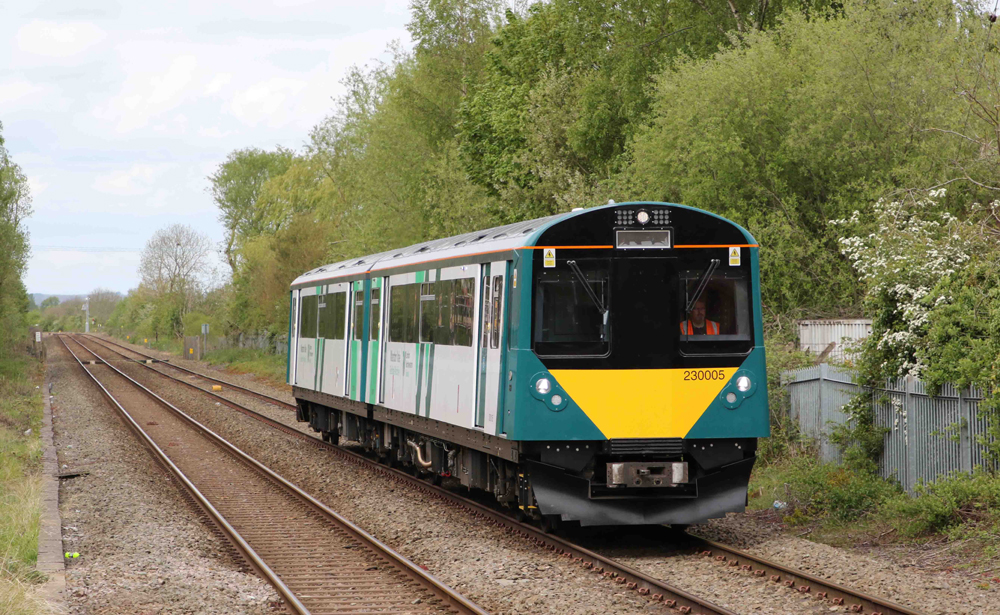 Silver, yellow, and green multiple-unit trainset in operation