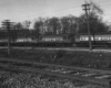 Wooden Chicago North Shore & Milwaukee equipment railcars parked on siding under wires