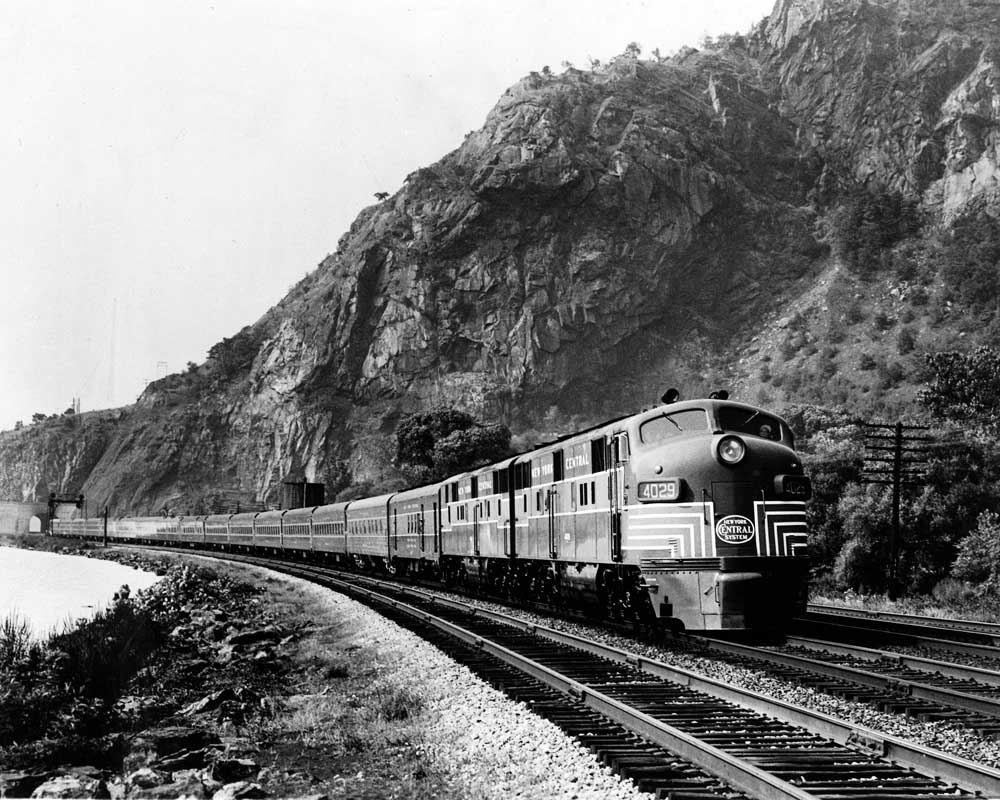 Streamlined diesel locomotives on 20th Century Limited passenger train along river