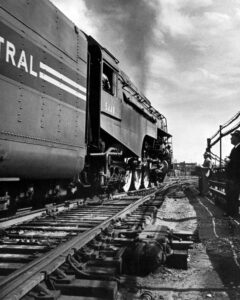 Streamlined steam locomotive on 20th Century Limited passenger train in city