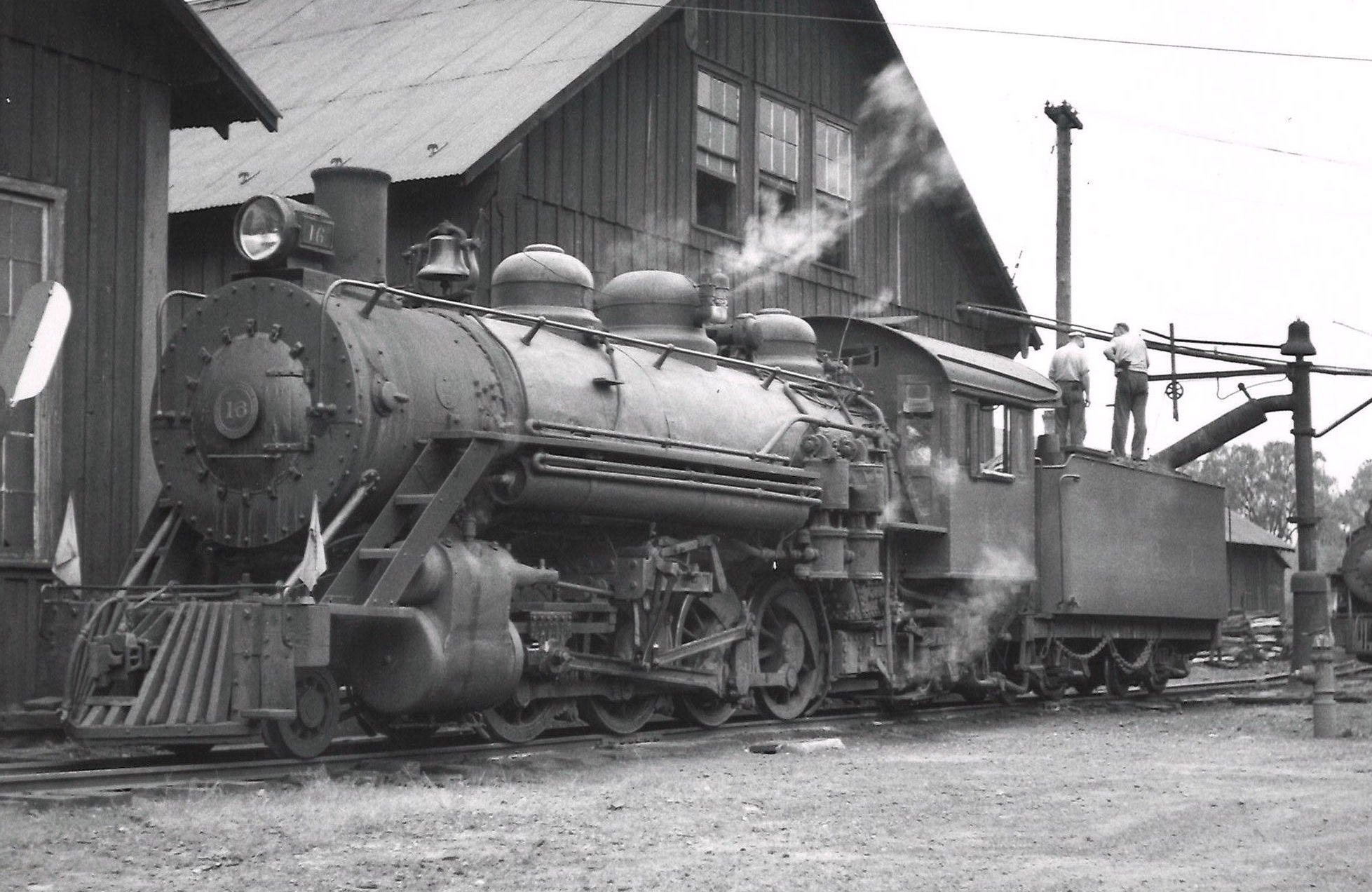 Steam locomotive taking on water. 