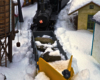 model steam locomotive plows snow with yellow snow plow