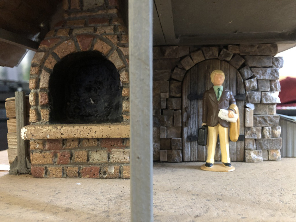 figure of a person next to a model structure