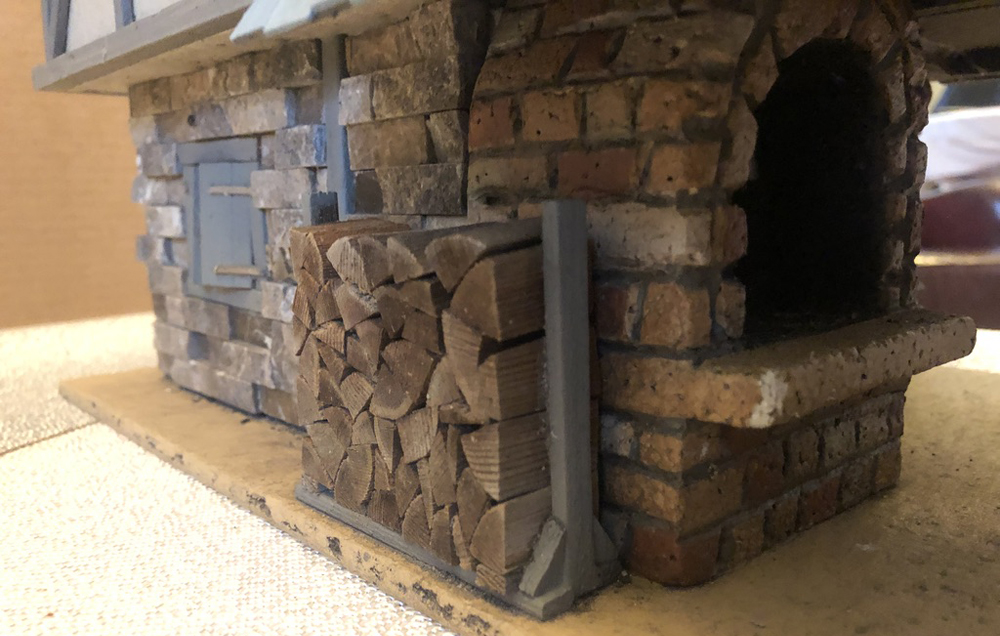 model firewood stack next to cottage