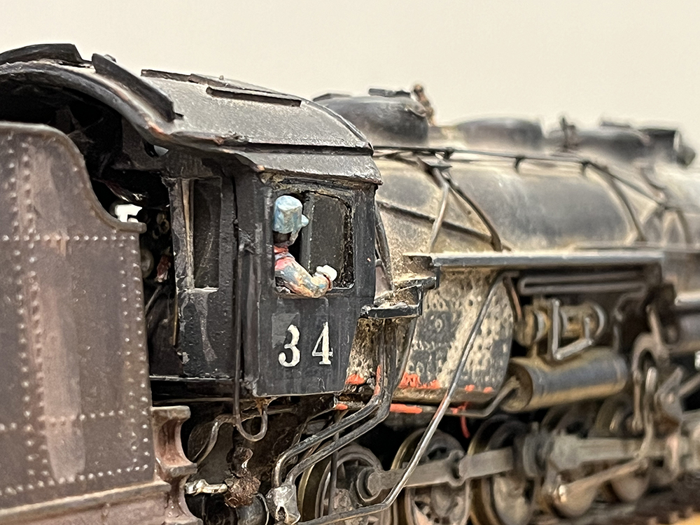 Model locomotive cab with miniature engineer figure