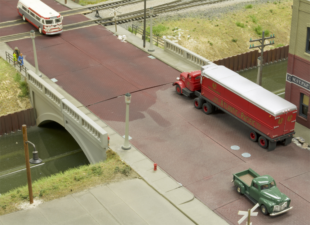 Image comparing dusty and clean sections of a model railroad.