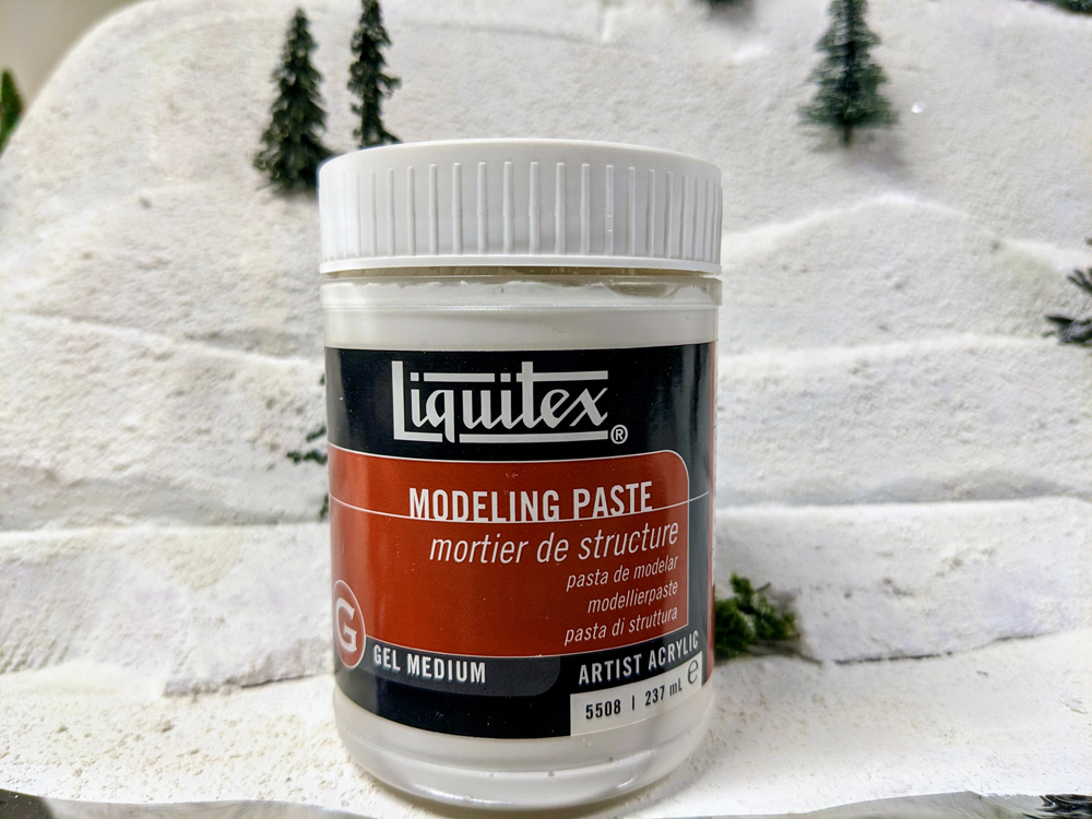 A white bottle with black and red label on snowy scenery base