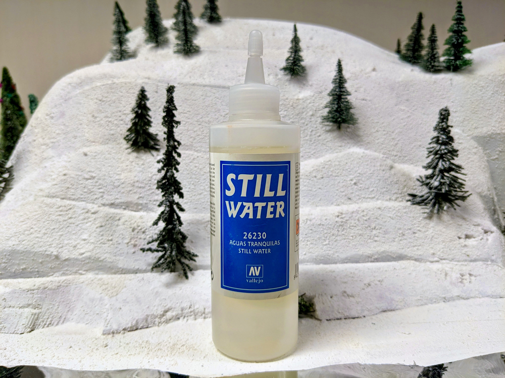 A clear bottle with blue label on snowy scenery base