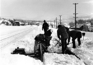 Group of men hand shoveling snow from a switch