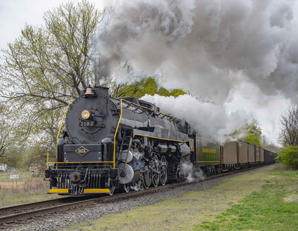 Steam locomotive pulling hopper cars
