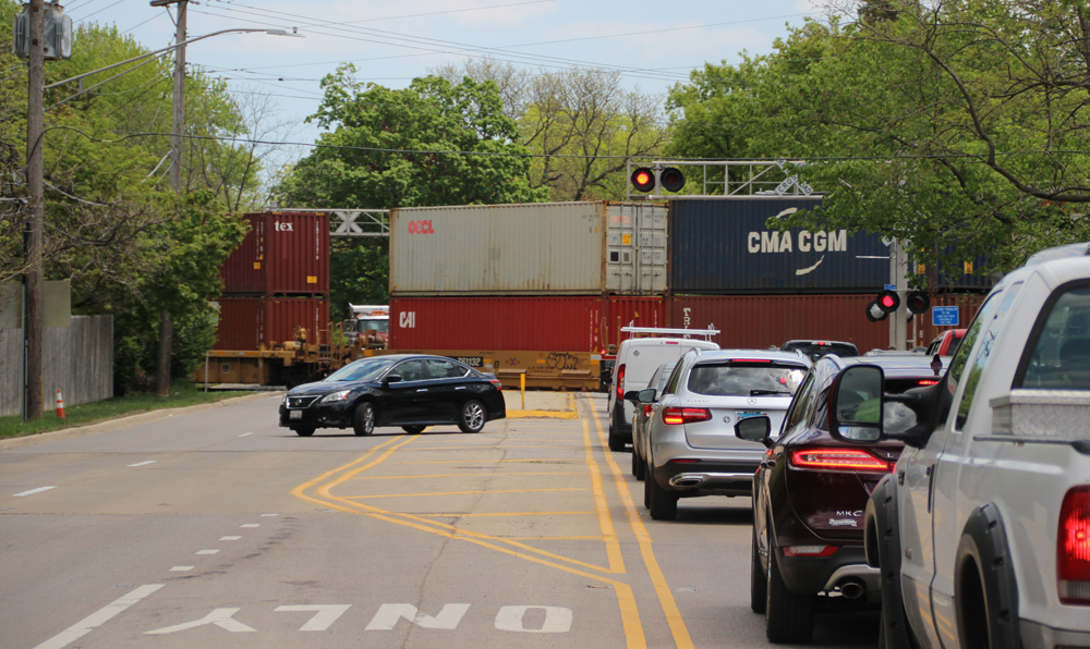 Car turning while train blocks street