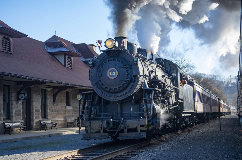 Steam locomotive and vintage passenger cars at station