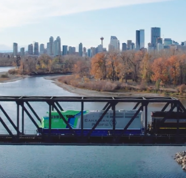 Green and gray locomotive on bridge