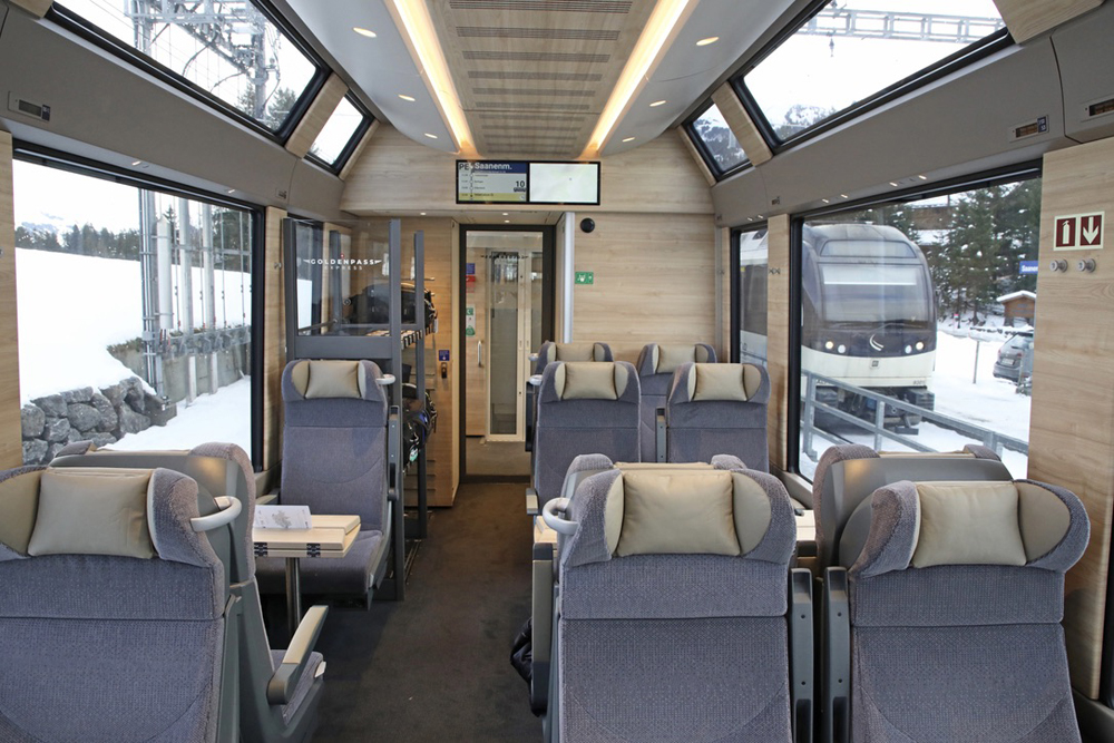 Interior of passenger car with gray seats and natural wood finish