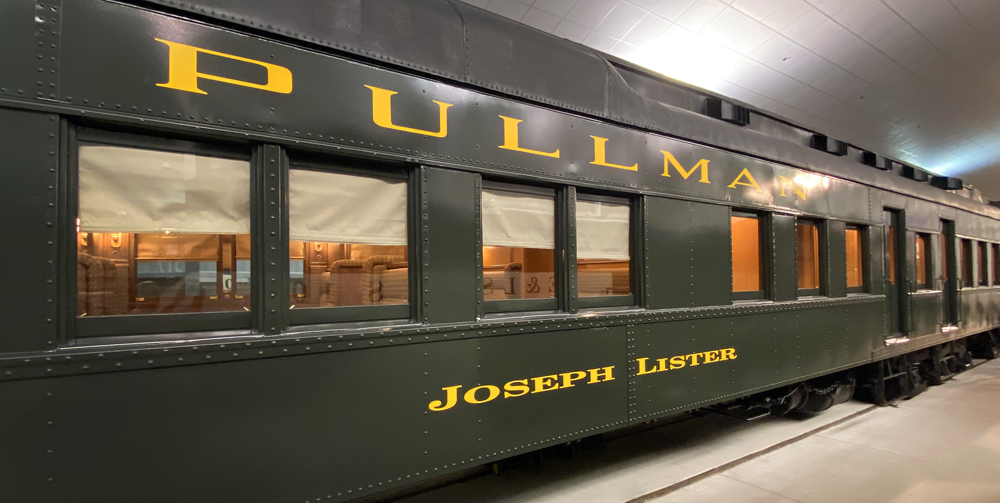 Outside of green heavyweight Pullman car in museum building