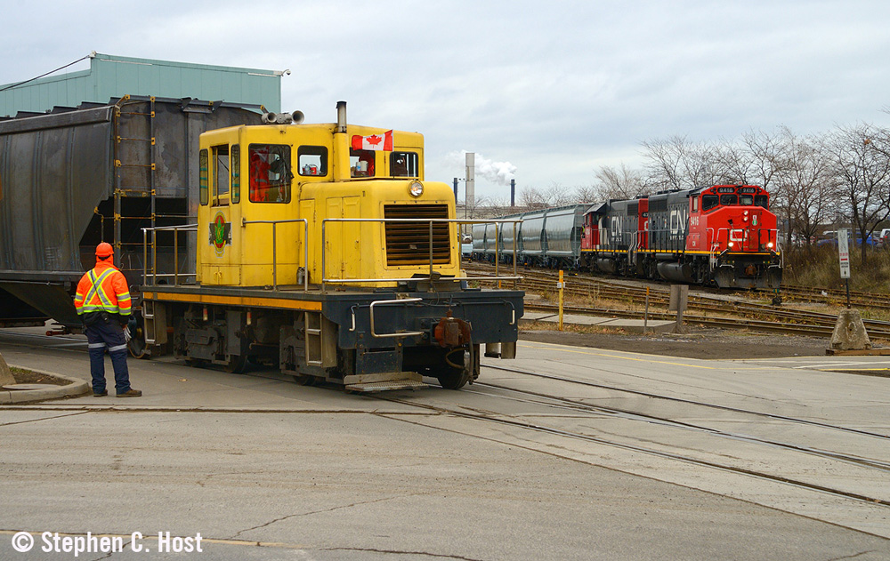 Yellow centercab switcher works with CN train in background