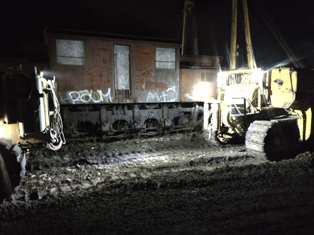 Heavy equipment works around locomotive at night