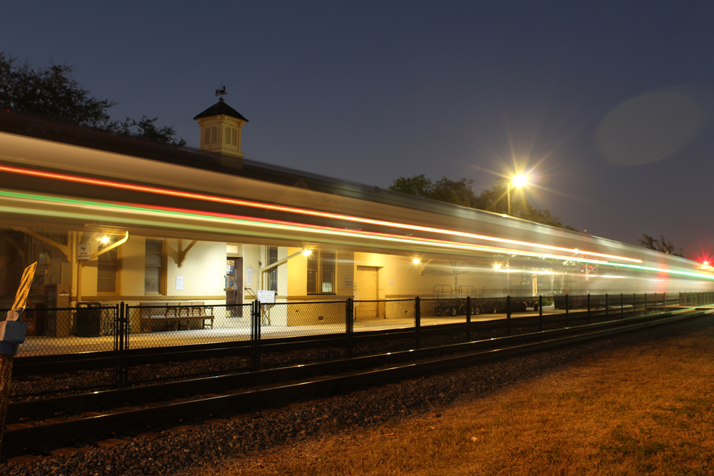 Passenger train is blurred by time-lapse photo at station