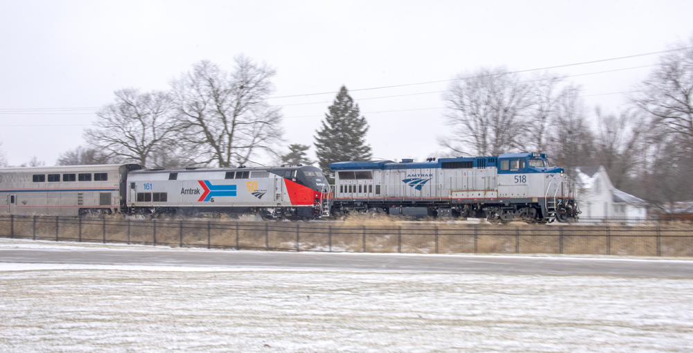 Pan shot of passenger train focusing on road-switcher as lead locomotive
