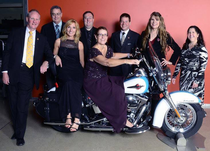 Group of people posed around motorcycle