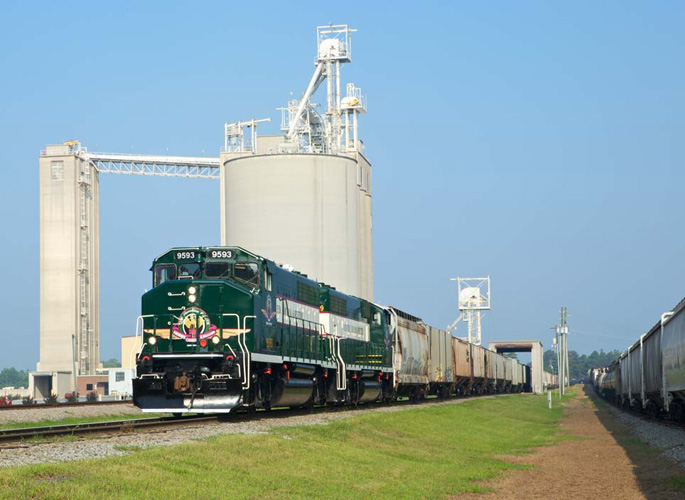 Green and white locomotives with freight train