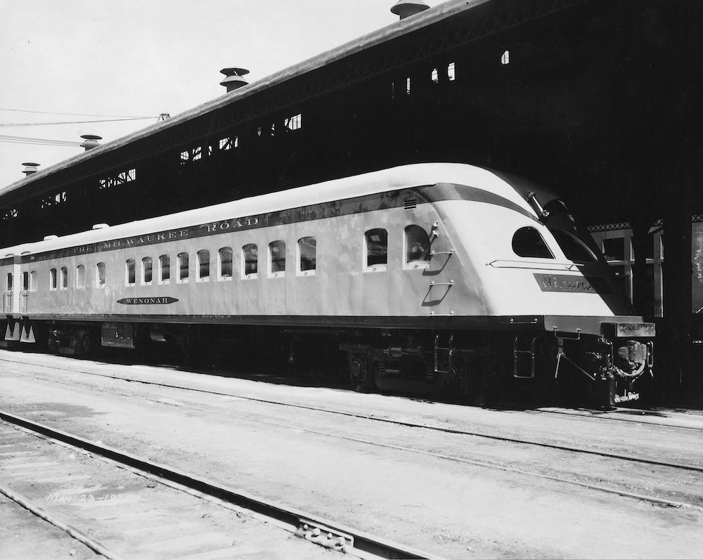 Black and white photo of an observation car at the train station.