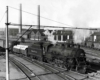 Steam locomotive with freight train in yard in urban environment