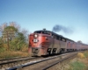 Streamlined red-and-black diesel locomotive on short passenger train on curve
