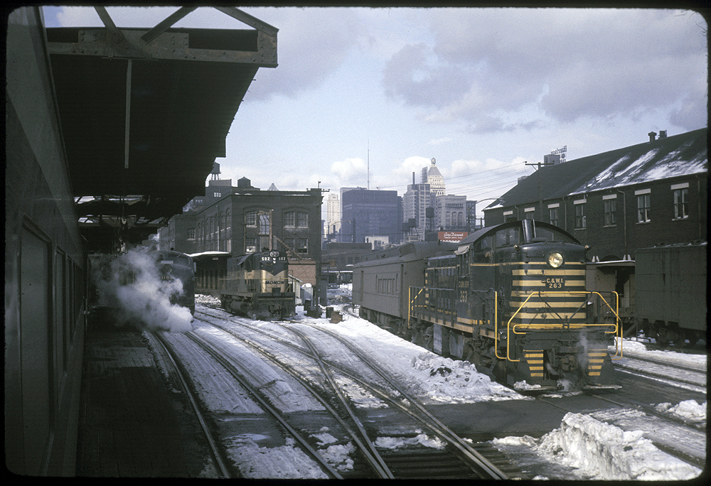 Trains in a snow covered rail yard.