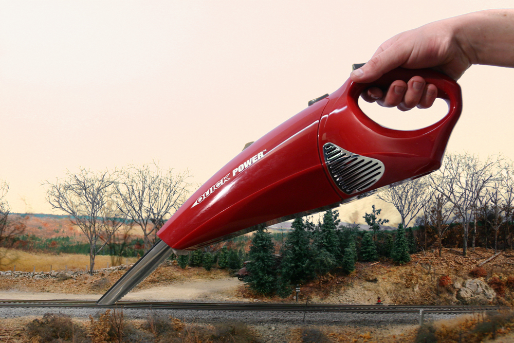 A red vacuum cleans dust from track