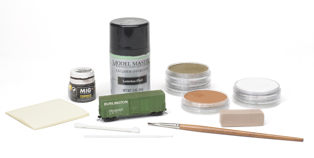 weather with powdered pastels: A green freight cars and a painting materials are shown in front of a white background
