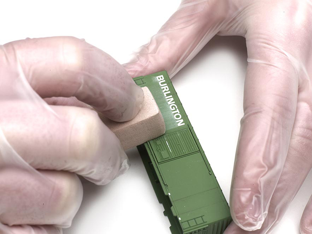weather with powdered pastels: A foam spongs is used on the lettering on the side of a freight car
