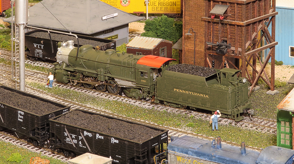 model steam locomotive next to coaling tower