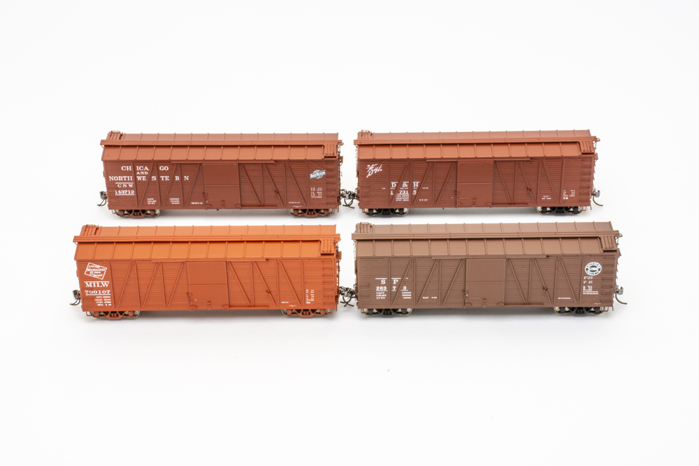 United States Railroad Administration single-sheathed boxcar: four orange and brown model boxcars are shown against a white background