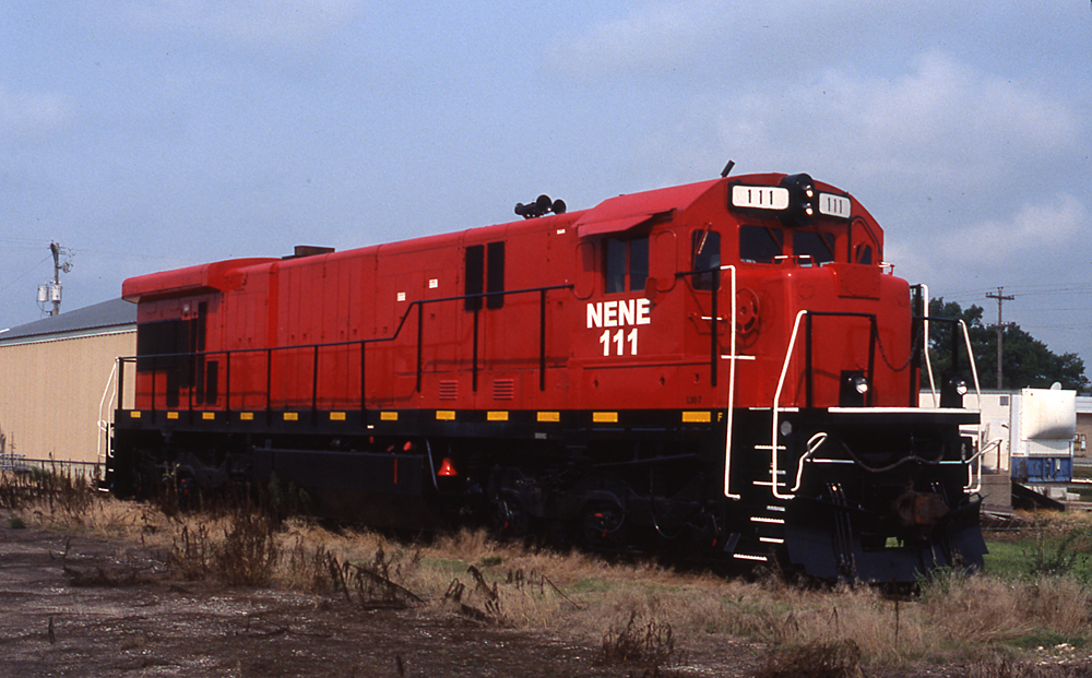 Photo of six-axle locomotive painted red and black with white graphics