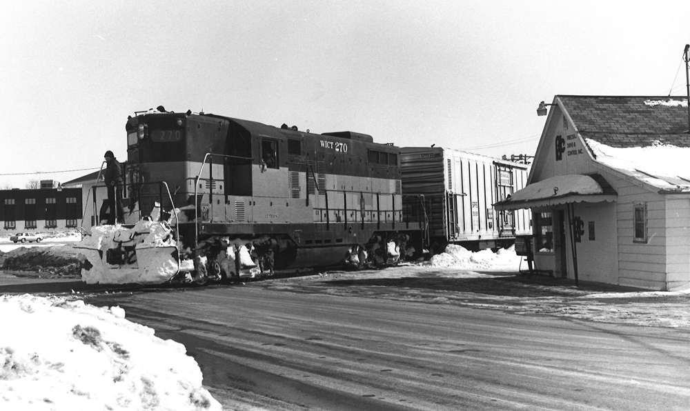 Black-and-white photo of GP9 at grade crossing in winter