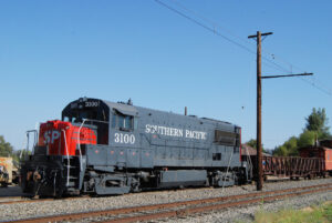 red and gray diesel locomotive pulling a freight train