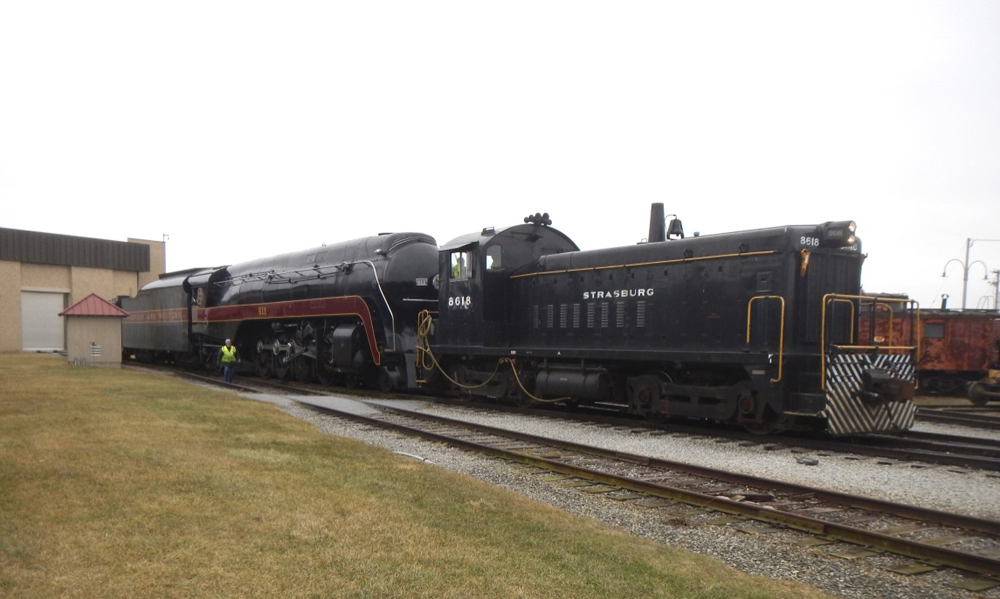 Black end-cab switcher with steam locomotive