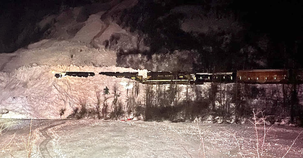 Train stopped in snow from avalanche in night photo