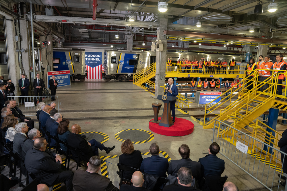 President of the U.S. speaking in rail facility surrounded by officials and railroad workers