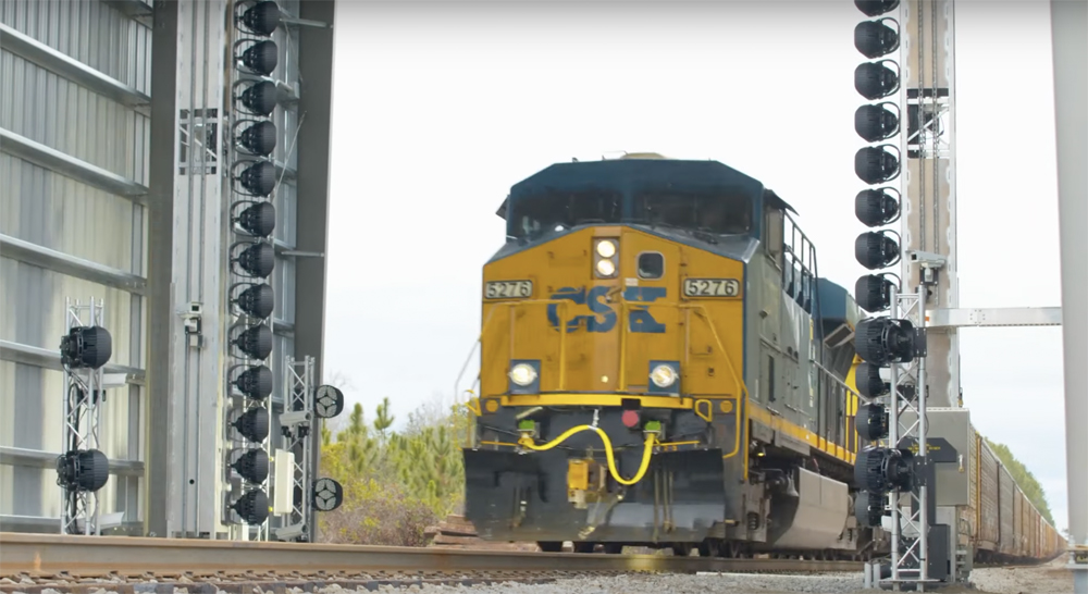 Train passes through shed-like structure over main line