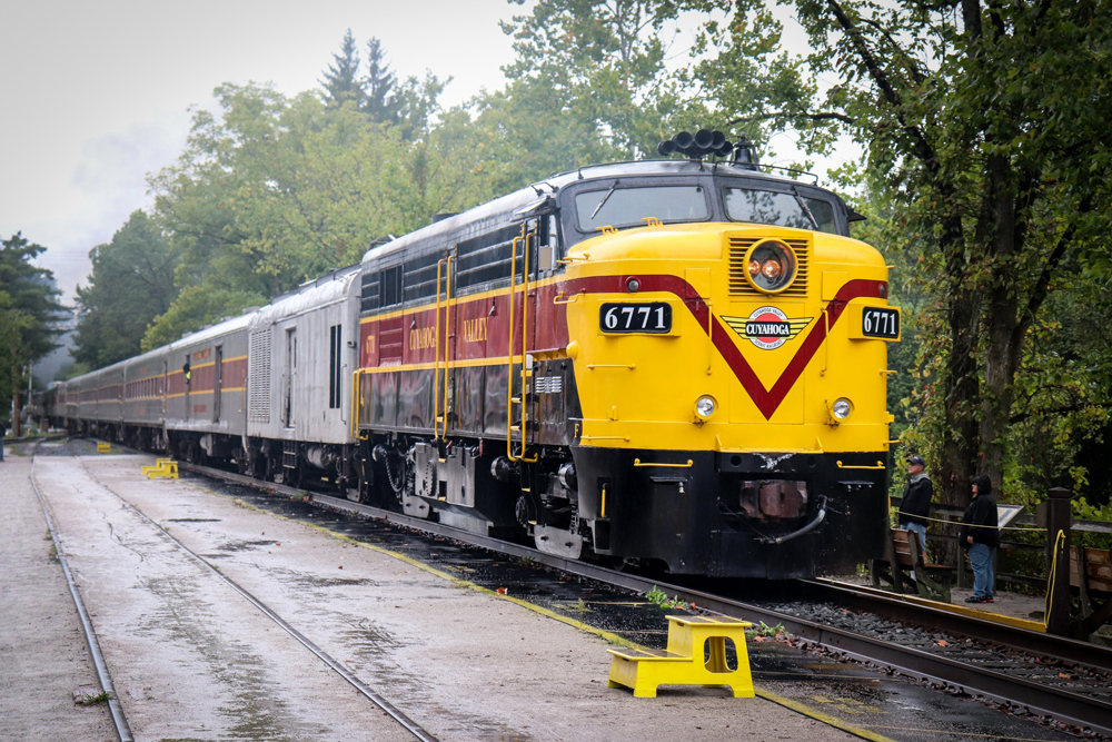Yellow, maroon, and black FA locomotive with passenger train